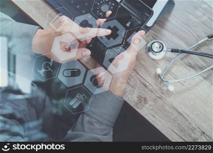 top view of medical doctor hand working with smart phone,digital tablet computer,stethoscope eyeglass,on wooden desk,virtual graphic interface icons screen
