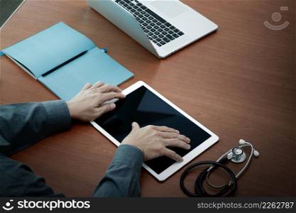 top view of Medicine doctor hand working with modern computer and digital pro tablet with blank screen on wooden desk as medical concept