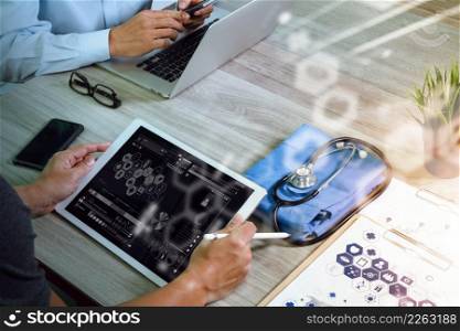 top view of Medicine doctor hand working with modern computer and digital pro tablet with his team with digital medical diagram on wooden desk as medical concept