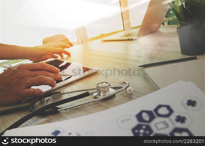 top view of Medicine doctor hand working with modern computer and digital pro tablet with blank screen with his team on wooden desk as medical concept