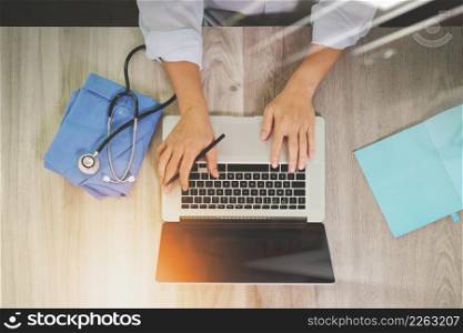 top view of Medicine doctor hand working with modern computer on wooden desk as medical concept