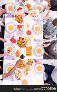 top view of modern multiethnic muslim family enjoying eating iftar dinner together during a ramadan feast at home