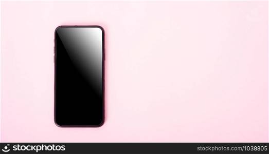 Top view of modern technology smart phone mobile on pink background with copy space