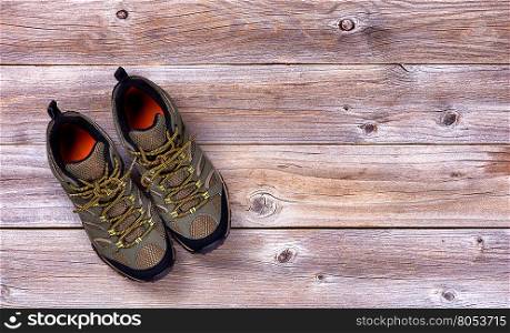 Top view of new hiking shoes on rustic wooden boards