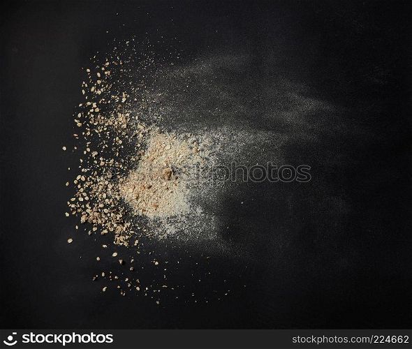 Top view of oat powder over black background. powder of oats