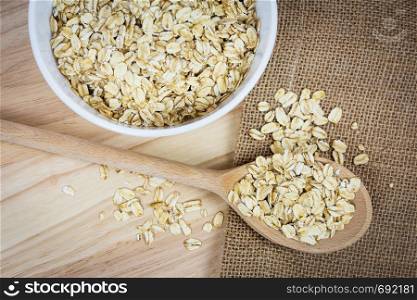 Top view of oatmeal flakes on a wooden table in a rustic style