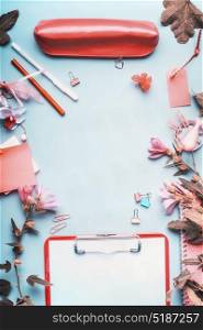 Top view of office table desk. Workspace with pen,clipboard ,accessories and flowers on blue background,frame