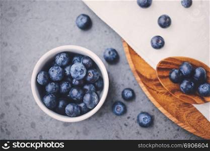 Top view of organic fresh blueberries with wooden spoon for breakfast meal