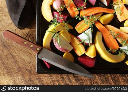 Top view of pan full of fall seasonal vegetables ready to be grilled over a wooden background .. Top view of pan full of fall seasonal vegetables ready to be grilled over a wooden background