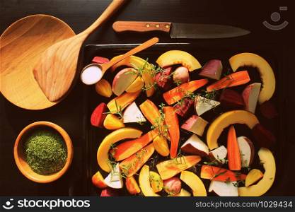 Top view of pan full of fall seasonal vegetables ready to be grilled over a dark background .. Top view of pan full of fall seasonal vegetables ready to be grilled over a dark background