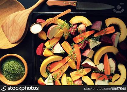 Top view of pan full of fall seasonal vegetables ready to be grilled over a dark background. Top view of pan full of fall seasonal vegetables ready to be grilled over a dark background .