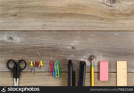 Top view of partial business and education supplies on rustic wood.