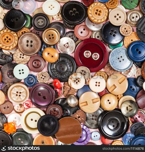 top view of pile of many various buttons close up on pink