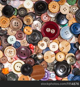 top view of pile of many various buttons close up on pink