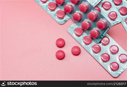 Top view of pink tablets pill and blister pack of pills on pink background. Prescription drugs. Pharmaceutical industry. Pharmacy drugstore banner. Health care and medicine. Tablets pills production.