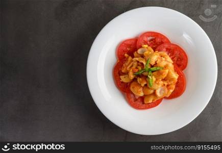 Top view of pipe rigate italian pasta with tomato sauce and egg, chili and fresh tomato slice in white plate, copy space