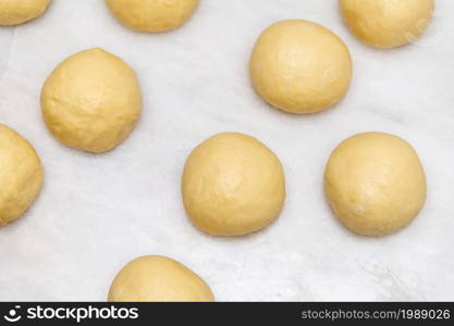 Top view of raw dough balls made for baking pastries on white marble