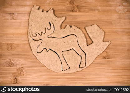 Top view of reindeer shaped raw gingerbread dough. Top view of reindeer shaped gingerbread dough