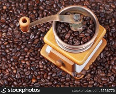 top view of retro manual coffee grinder on many roasted coffee beans