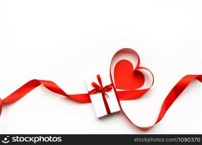 Top view of ribbon shaped as heart and gift box isolated on white background. Valentine&rsquo;s day concept. Copyspace. Top view of ribbon shaped as heart and gift box isolated on white background. Valentine&rsquo;s day concept.