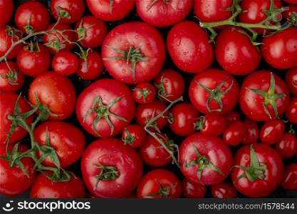 top view of ripe fresh tomatoes with water drops on black background