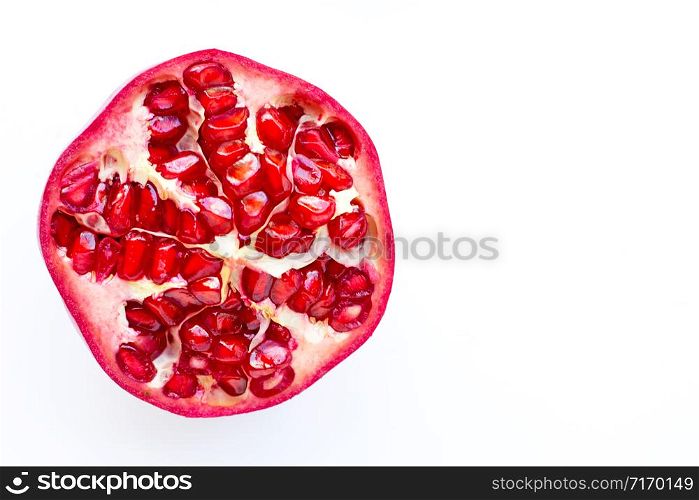 Top view of ripe pomegranate fruiton white background. Copy space