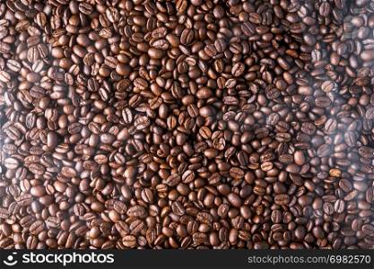 top view of roasted coffee beans background with smoke
