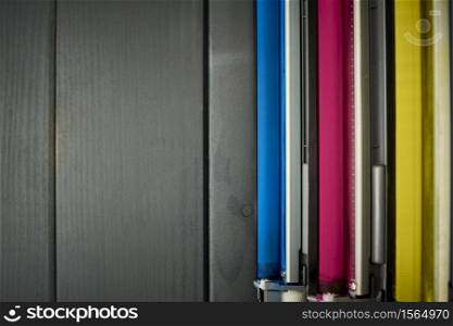 Top view of rollers in a set of laser printer color cartridges on gray wooden background
