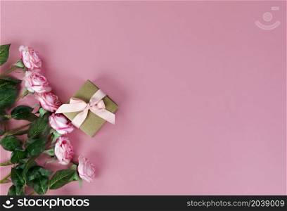 Top view of roses on pink background for Mothers Day holiday concept Top view of roses and gift box on pink background for Mothers Day holiday concept
