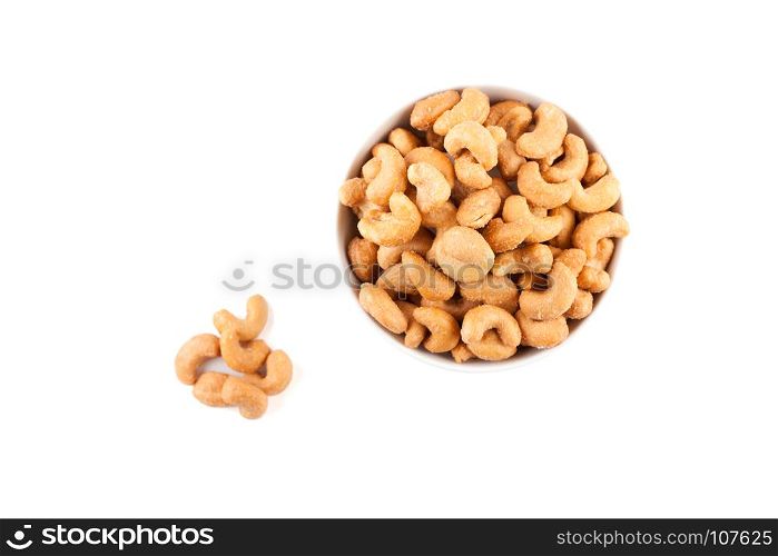 top view of salted cashew nuts in white ceramic bowl isolated on white background with clipping path