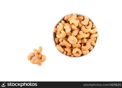 top view of salted cashew nuts in white ceramic bowl isolated on white background with clipping path