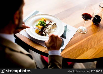 Top view of senior man eating lunch in restaurant