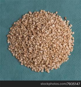 Top view of sesame seeds against blue vinyl background.