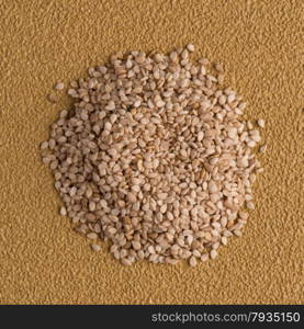 Top view of sesame seeds against yellow vinyl background.