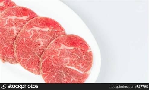 Top view of some raw beef on a plate over white background. raw beef on a plate