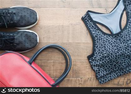 Top view of sport woman items on wooden background, Sport shoes, sport bra and bag