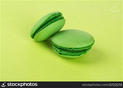 top view of tasty green macaroons on green background