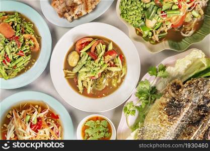 top view of thai spicy food and grilled fish. spicy cucumber salad , thai spicy food
