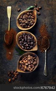 Top view of three different varieties of coffee beans on dark vintage background