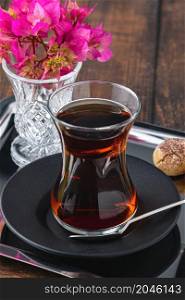 Top view of traditional black turkish tea with lemon and cookies on wooden background