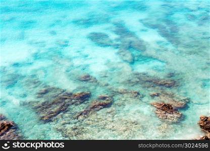Top view of transparent shallow turquoise ocean sea water surface and rock at andaman sea indian ocean in summer.