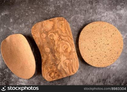 Top view of Two cork plates and wood board on dark grey countertop.