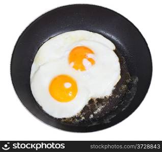 top view of two fried eggs in frying pan isolated on white background
