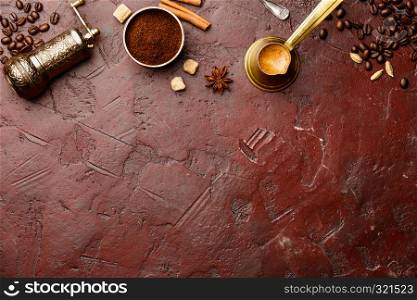 Top view of vintage manual coffee grinder, coffee beans and spices, space for text, red background