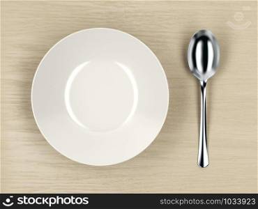 Top view of white empty soup bowl and silver spoon on wood table