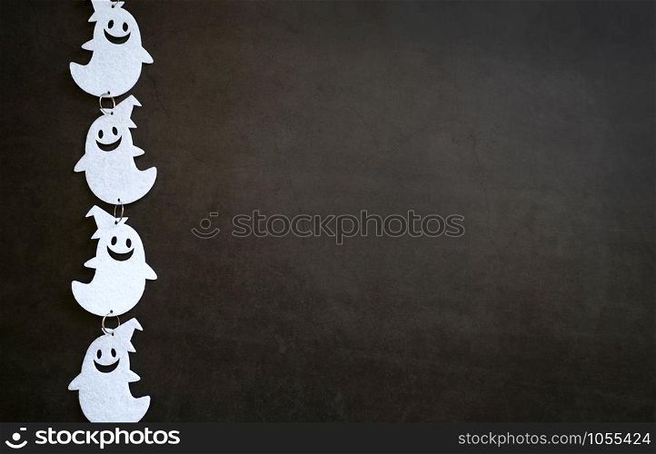 Top view of white ghost decoration on dark stone background with copy space, trick or treat for halloween