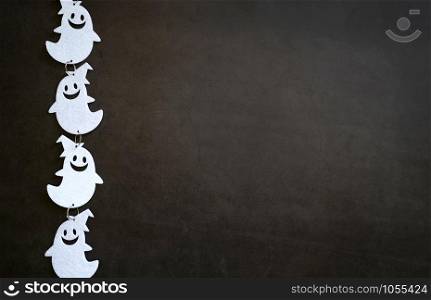 Top view of white ghost decoration on dark stone background with copy space, trick or treat for halloween