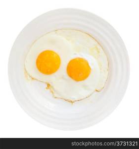 top view of white plate with two fried eggs isolated on white background