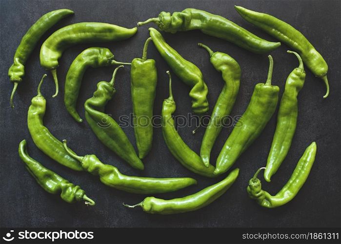 Top view of whole raw green peppers on dark background. Top view of whole green peppers on dark background
