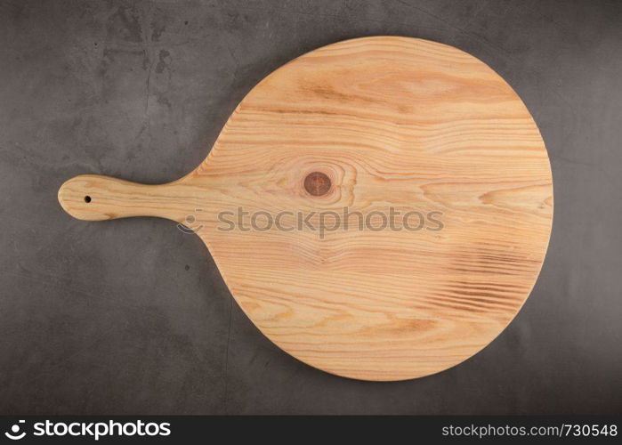 Top view of wooden cutting board on old concrete countertop.